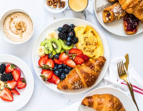 "Overhead shot of a sophisticated hotel breakfast buffet plate: miniature pastries, fruit, and a small omelet. Elegant colors, meticulous details, cinematic presentation, 4K."