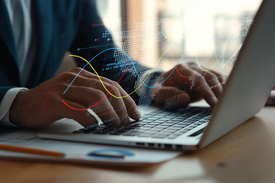 Hands typing on laptop with digital graphs and data visualization overlay, showcasing modern technology and business analytics in a professional workspace
