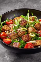 Tofu cubes, cherry tomatoes, arugula, & scallions in a bowl