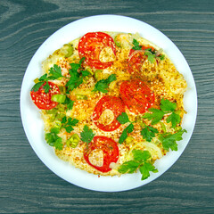 Delicious vegetarian dish featuring tomatoes, spices, and herbs on a white plate