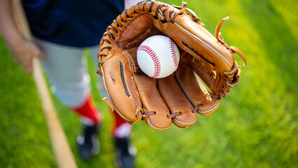 Baseball player in uniform with glove and bat image