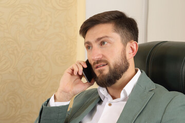Businessman engaged in a phone call in a modern office setting during the day