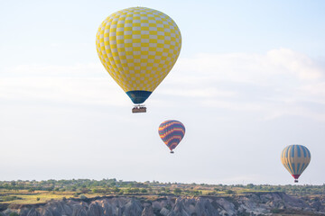 Obraz premium Hot air balloons soaring above the stunning landscapes of Cappadocia, Turkey during sunrise