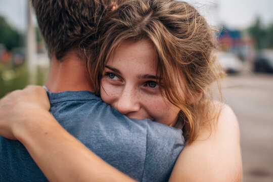 Loving young couple sharing a happy and intimate hug during an emotional reunion or farewell - Powered by Adobe