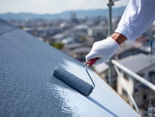 屋根をローラーで塗装する作業員の手元