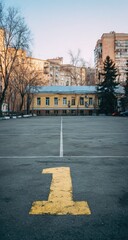 Empty paved courtyard with a yellow number one