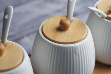 Elegant white ceramic containers with bamboo lids displayed