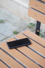 Smartphone placed on wooden bench. lost smart phone concept 