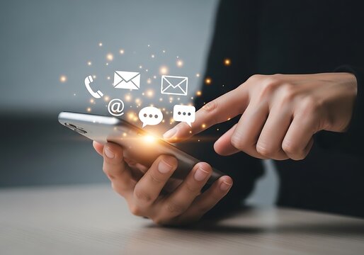 Photo of closeup of a persons hand using a smartphone with various communication icons and glowing particles