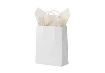 A simple white paper gift bag with delicate tissue paper peeking out from the top isolated on transparent background