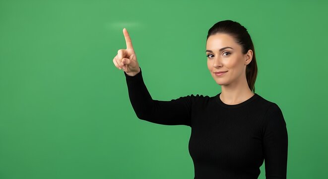 Woman in black top interacts with a virtual interface, finger pointing at a glowing element against a green screen.