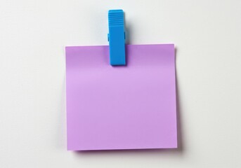 A single lavender sticky note held by a bright blue clothes pin