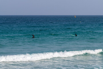 idyllic seascape with the people enjoying surfing 