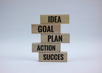 Stacked Wooden Blocks Representing Idea, Plan, Action, Goal, and Success. isolated on white...