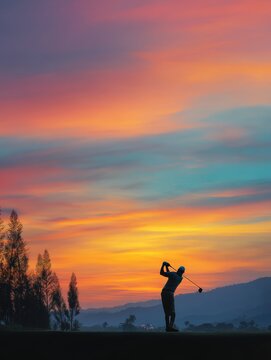 Golfer Silhouette Swinging Club Against Vibrant Sunset Sky with Colorful Clouds