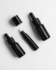 Obraz premium Black cosmetic bottles and droppers on white background