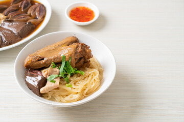 dried noodles with braised duck in white bowl