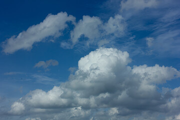 Bright blue sky with fluffy white cumulus clouds on a sunny day. Perfect natural background with copy space