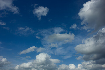 Vibrant blue sky with various types of white and grey clouds on a sunny day. Natural background with copy space.
