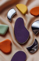 Gua sha stones and cosmetic sponges resting on beige satin cloth