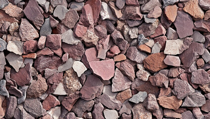 Close up textured background of rough broken reddish brown and grey natural stone aggregate pieces