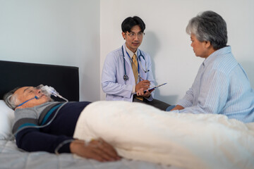 Fototapeta premium doctor explaining medical treatment for bedridden patient elderly hopeless senior man lying on bed. home caregiver nurse visit retirement patient for health check up recovery process medical service