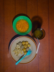 a traditional Indonesian street food meal featuring meatballs fried wontons, and spicy chili sauce...