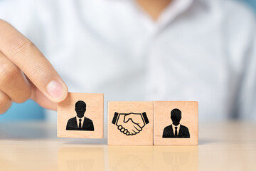 Wooden cubes with handshake and people icons, symbolizing business partnership, cooperation, and...