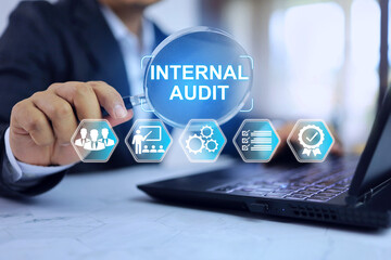 Internal audit concept with businessman using magnifying glass to checkup document activity operation to comply with procedure which must be done annually before external audit