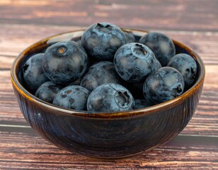 Fresh blueberries in a ceramic bowl showcasing vibrant color and texture on rustic wooden background