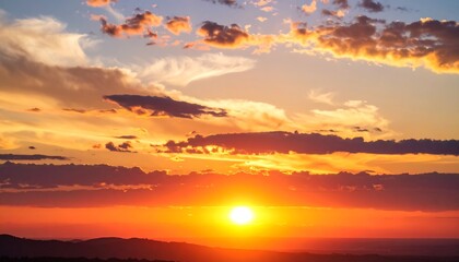 Fototapeta premium Vibrant sunset with fiery hues and scattered clouds over a silhouetted landscape