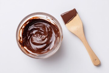 Creamy Melted Chocolate in Bowl with Wooden Spatula on White Surface