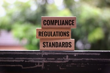 Stacked Blocks Displaying Compliance Regulations and Standards in Business Environment. isolated on a blurred background
