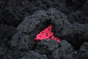 Molten rock red, hidden in dark volcanic