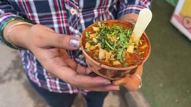 A girl holding famous Benaras tomato chat