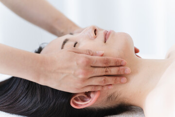 エステティシャンに施術を受ける若い女性　ビューティイメージ