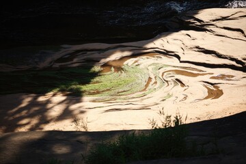 Shallow stream bed, sunlight patterns, and shadows