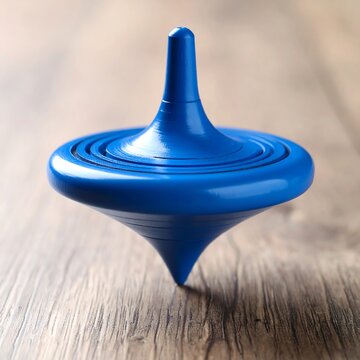 A blue spinning top rests on a wood surface