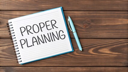Proper planning written on a notebook with a pen on a wooden desk, emphasizing the importance of organization and strategy