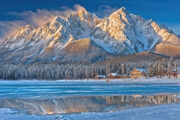 Fototapeta premium Winter wonderland landscape with snowy peaks reflecting on a frozen lake