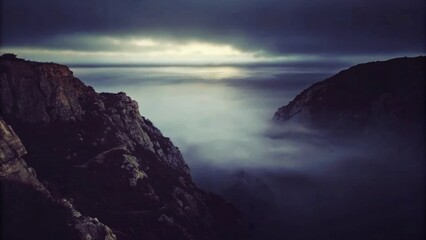 Fototapeta premium Misty, dramatic rocks by the sea.