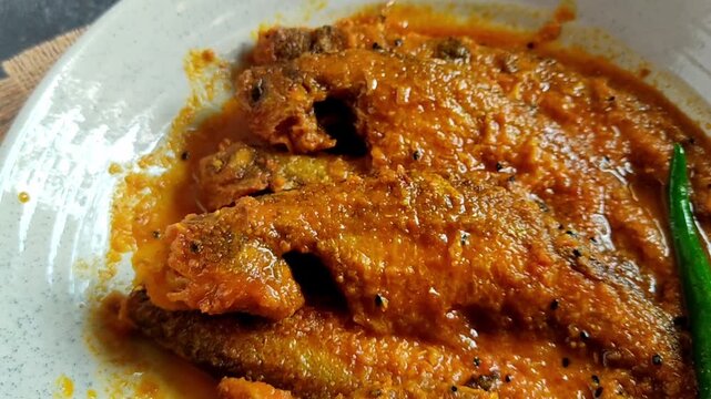 Bengali-style pabda fish jhal with tomato bata &ndash; traditional Indian mustard fish curry, spicy river fish recipe, homestyle Bengali cuisine, served in bowl