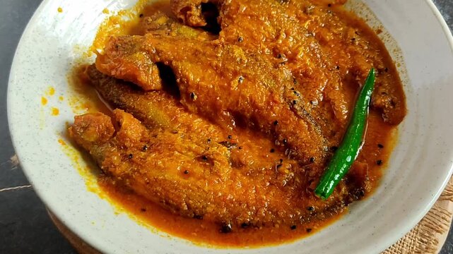 Bengali-style pabda fish jhal with tomato bata &ndash; traditional Indian mustard fish curry, spicy river fish recipe, homestyle Bengali cuisine, served in bowl