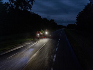 Dynamic motion blur image of night cyclists in action with speed and movement creating artistic effect