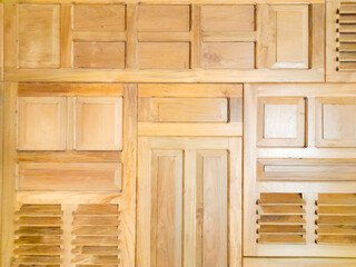 An abstract and symmetrical composition of various wooden panels, textures, and slats creating a...