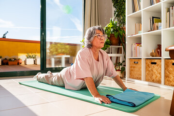 Senior Woman Practicing Upward Facing Dog Pose to Enhance Flexibility and Stretch Her Back