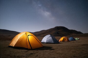 Glowing tents under starry night sky in remote mountain landscape.