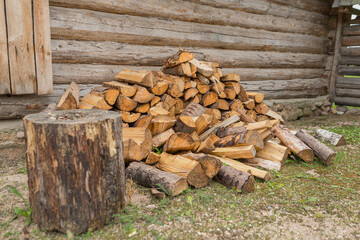 Pile of Firewood Logs Stacked Outside Rustic Wooden Shed in Rural Countryside. Freshly Cut Firewood...