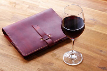 Red wine glass and notebook on table

