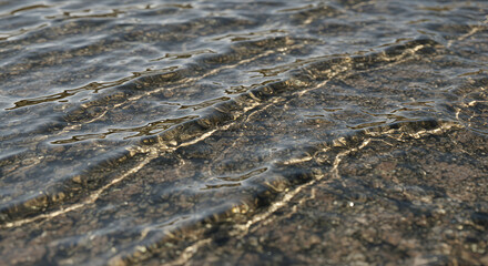 Obraz premium Rippled water over a bed of stones